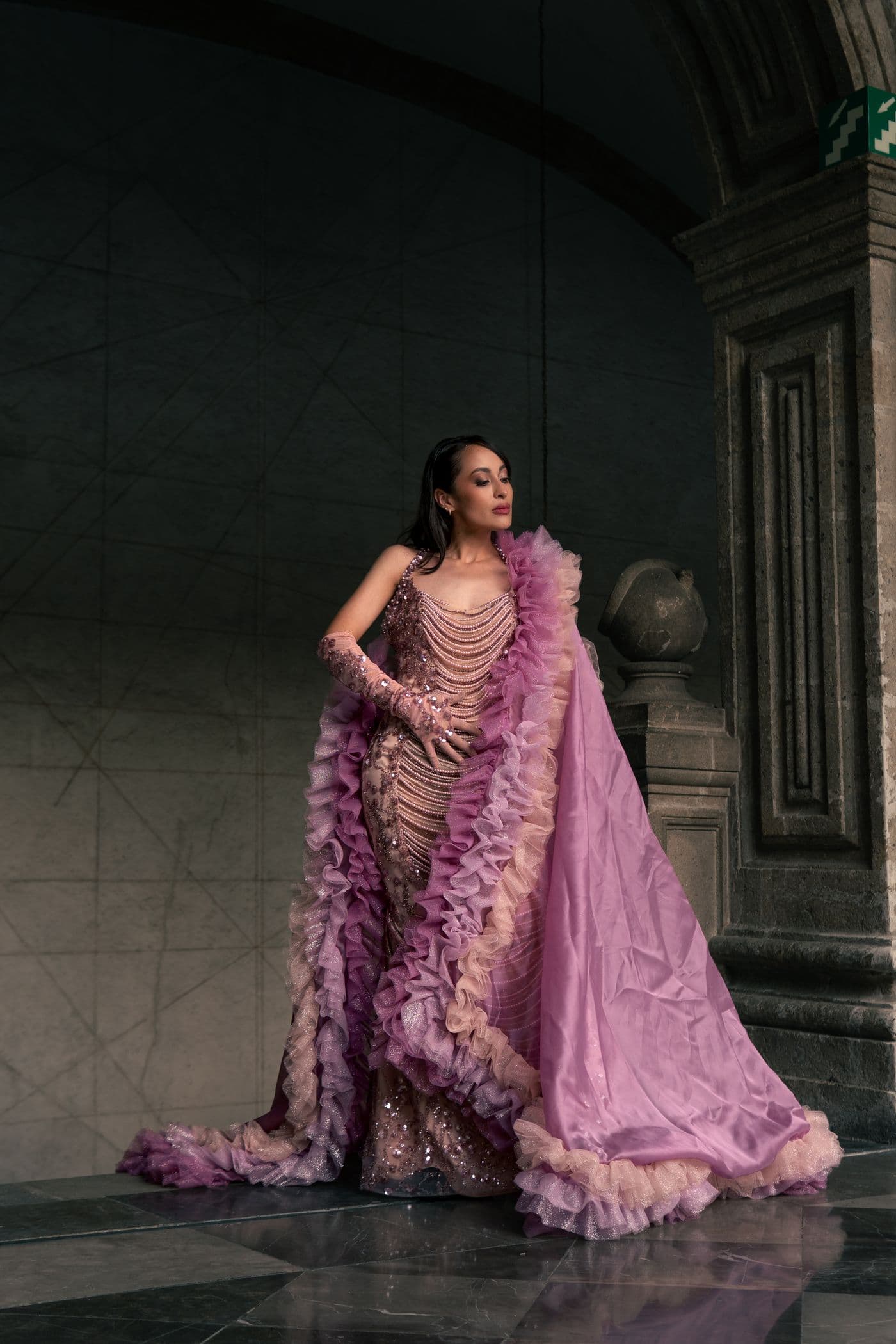 Model in a voluminous blush pink gown in an ornate interior