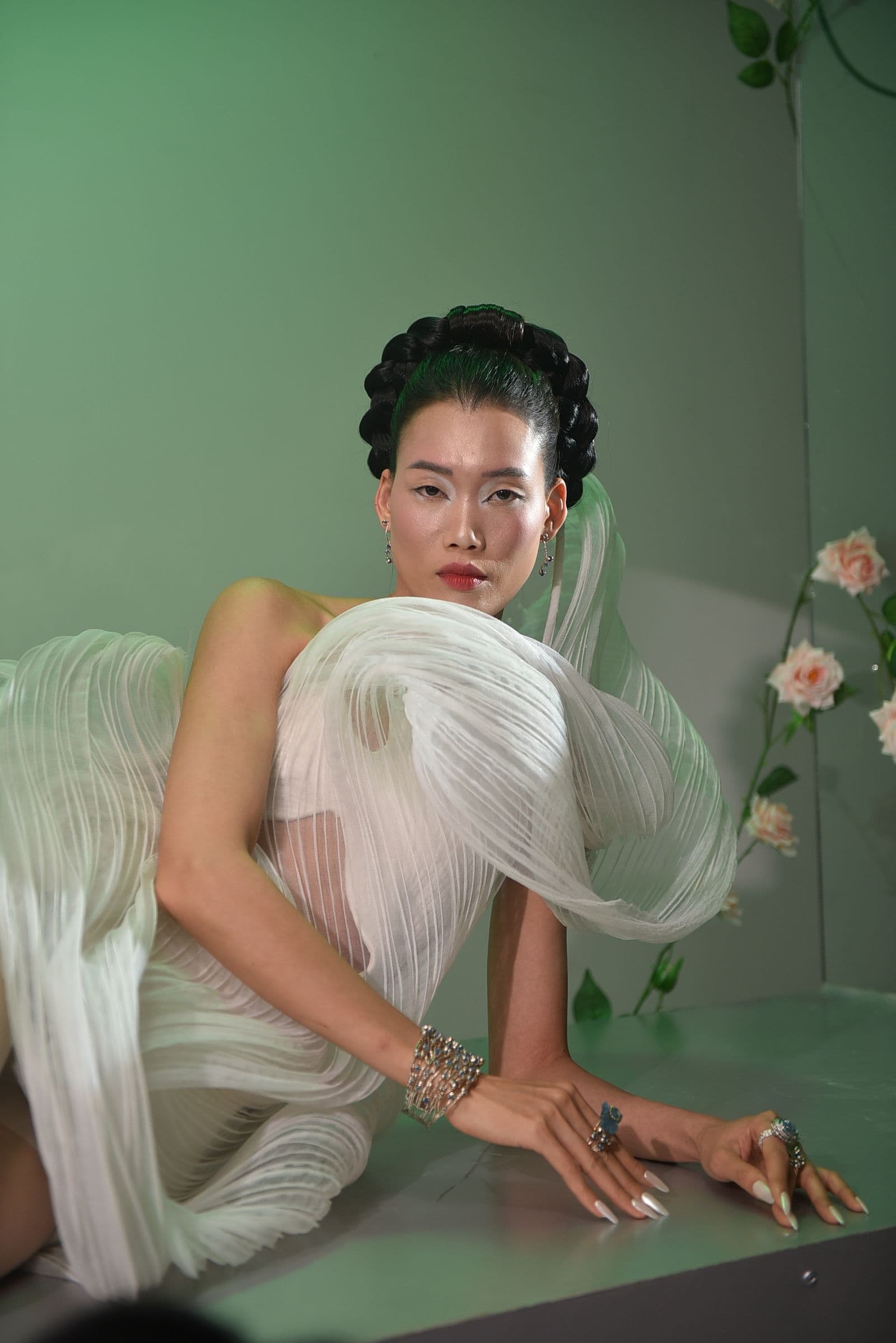 Model in a softly draped ivory gown photographed against a pale backdrop