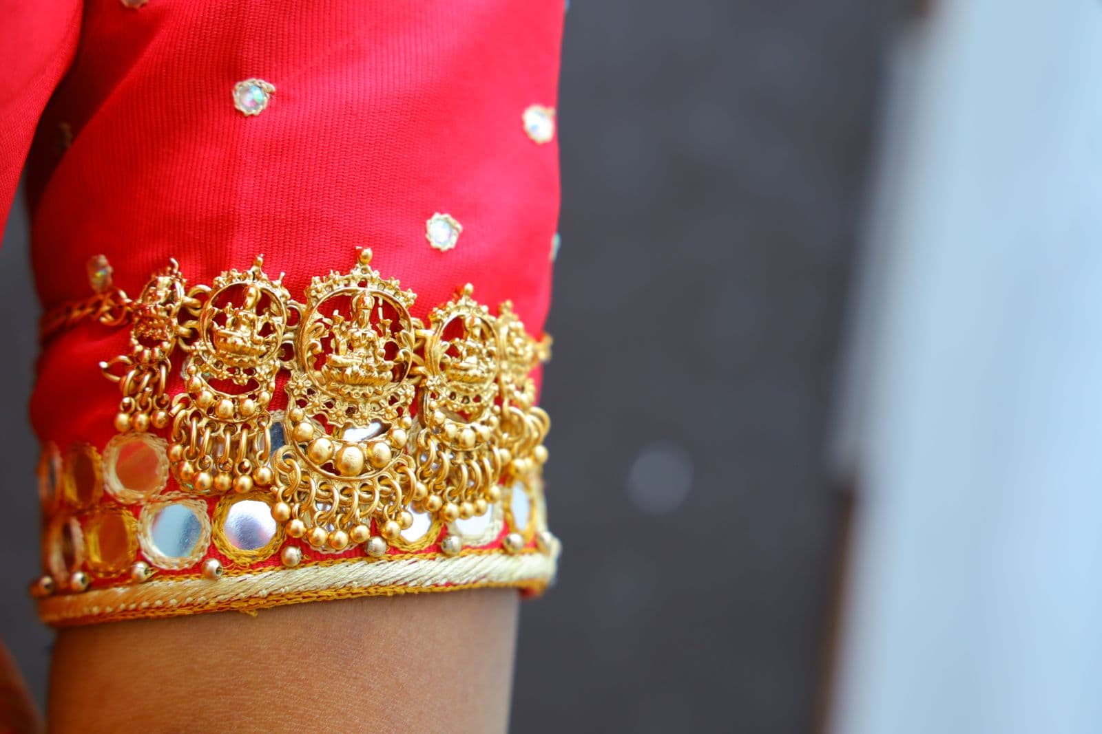 Close-up of intricate gold embroidery on a red sleeve