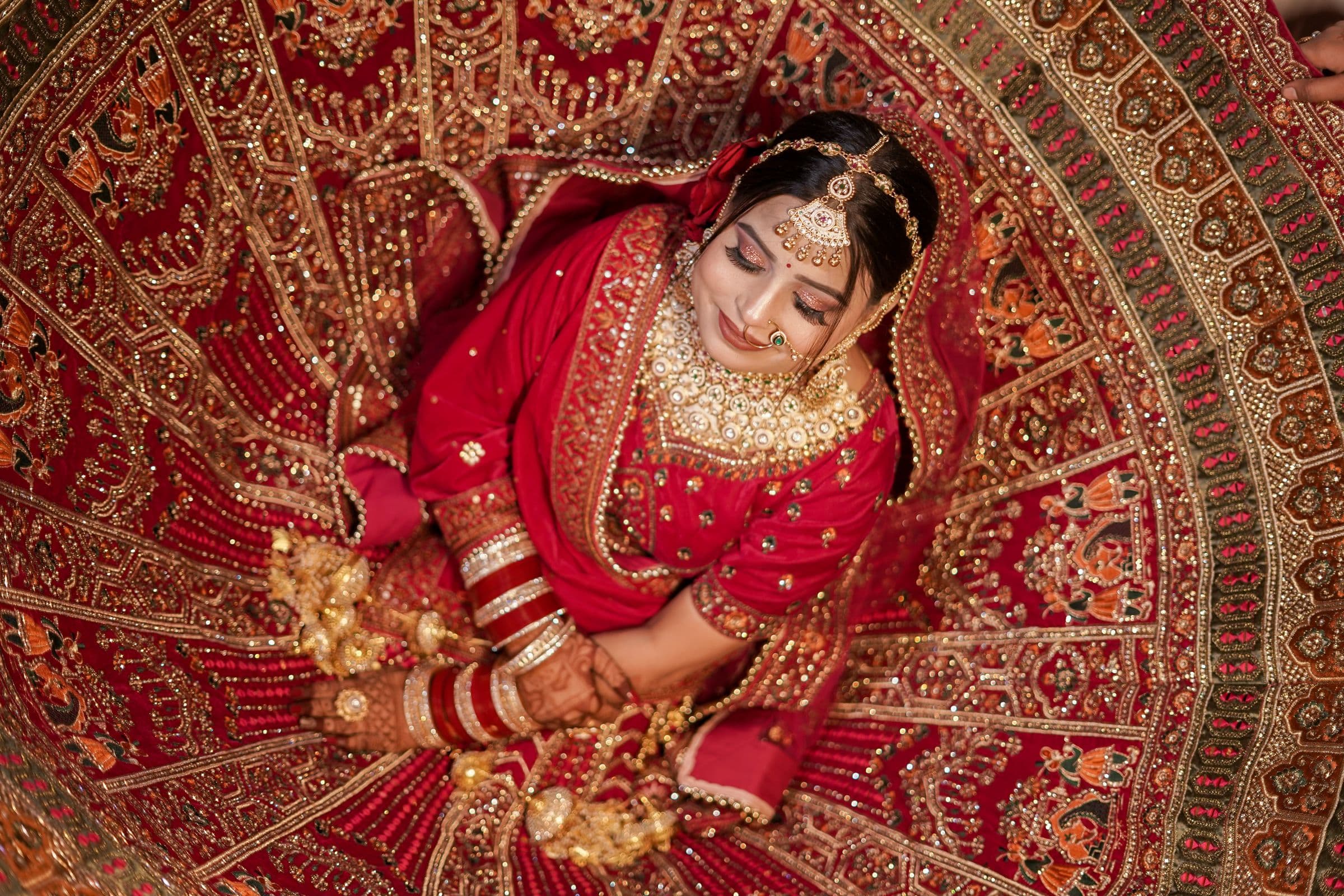 ONERA bride in a hand-embroidered red couture lehenga, photographed from above
