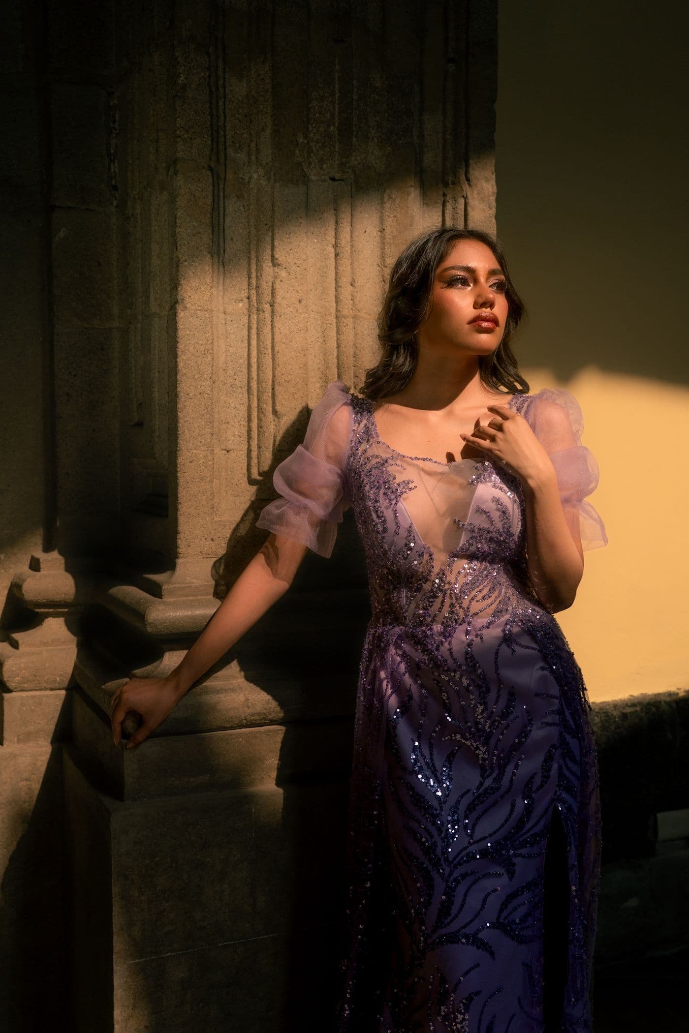 Model in a dramatic purple gown on a staircase