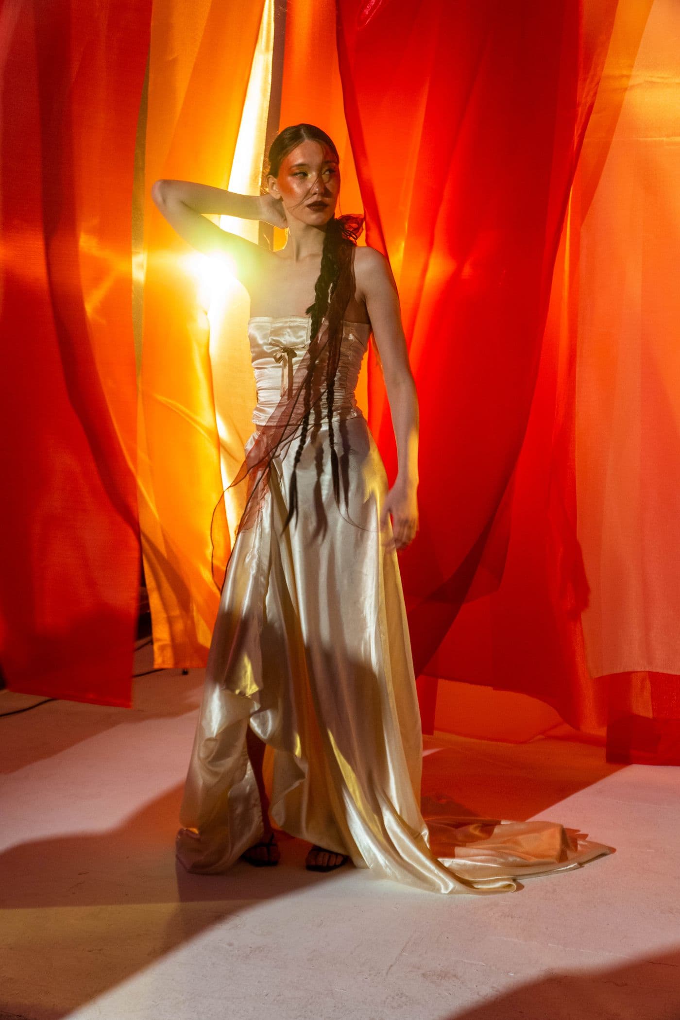 Model in a molten gold gown under dramatic light
