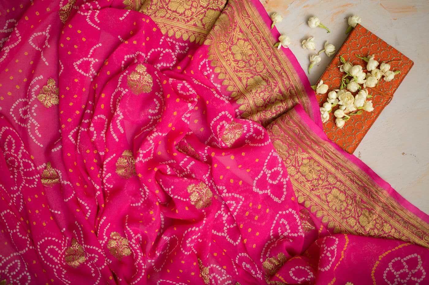 Rich rose-pink fabric with dense gold floral embroidery
